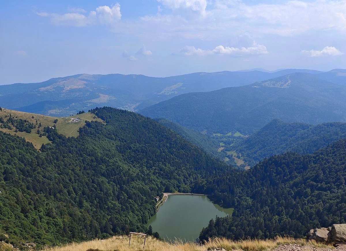 Vue depuis les crêtes sur les ballons boisés et un lac de montagne